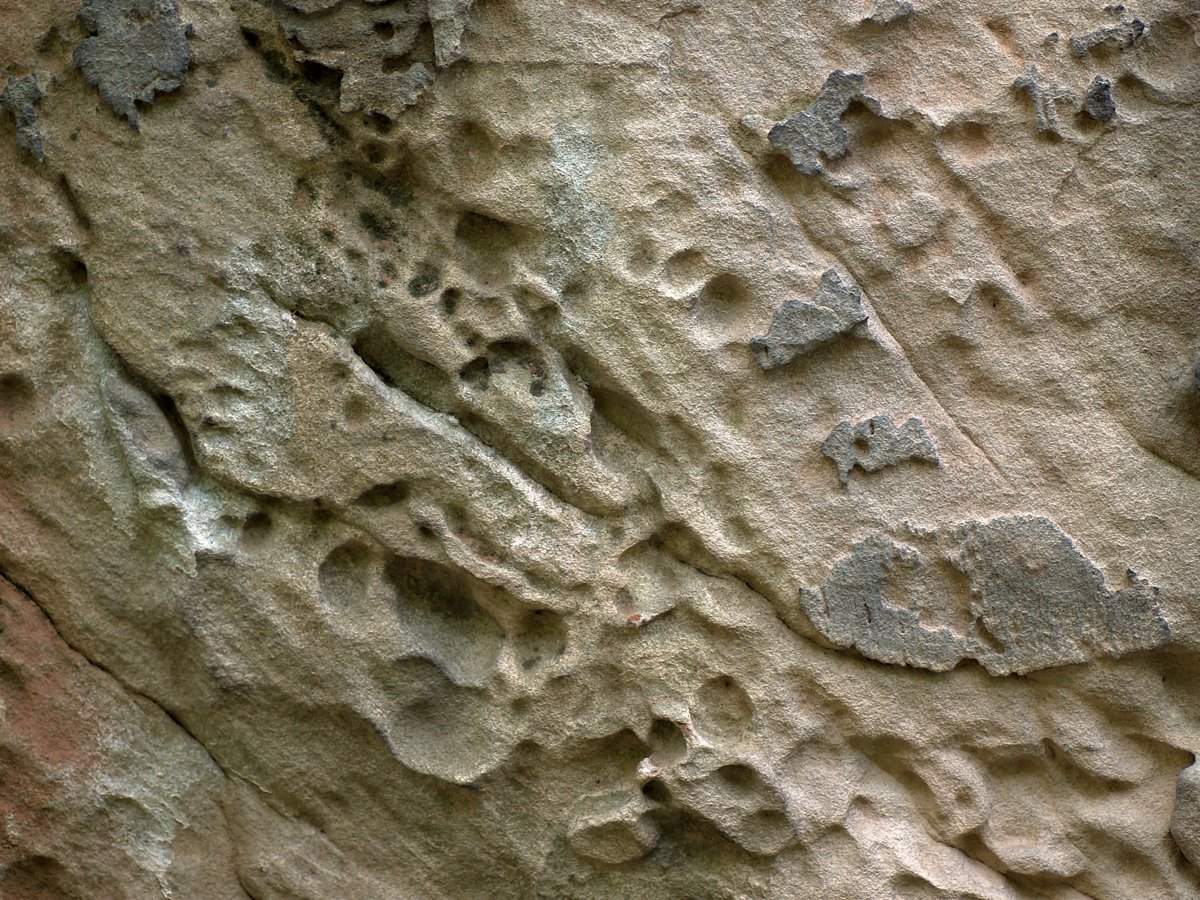 a wall with multiple footprints made of dirt