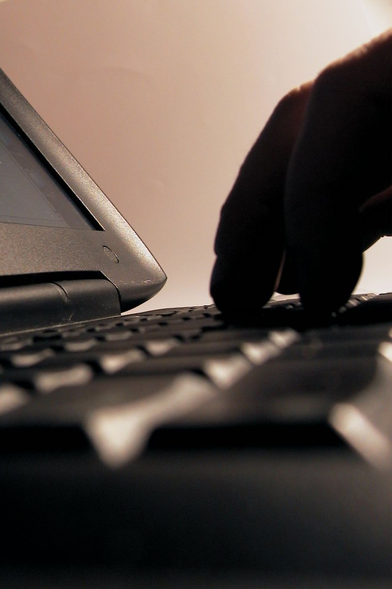 a hand typing on a laptop keyboard