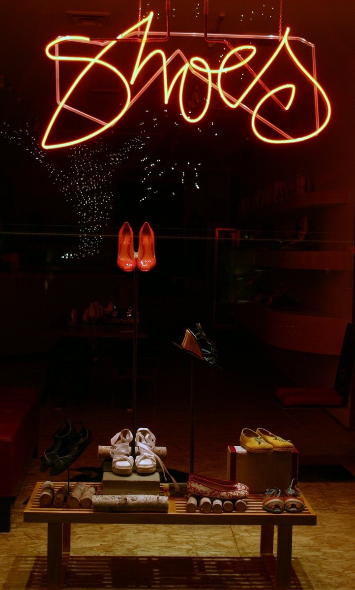 neon lights are shining in front of a neon sign above a display table