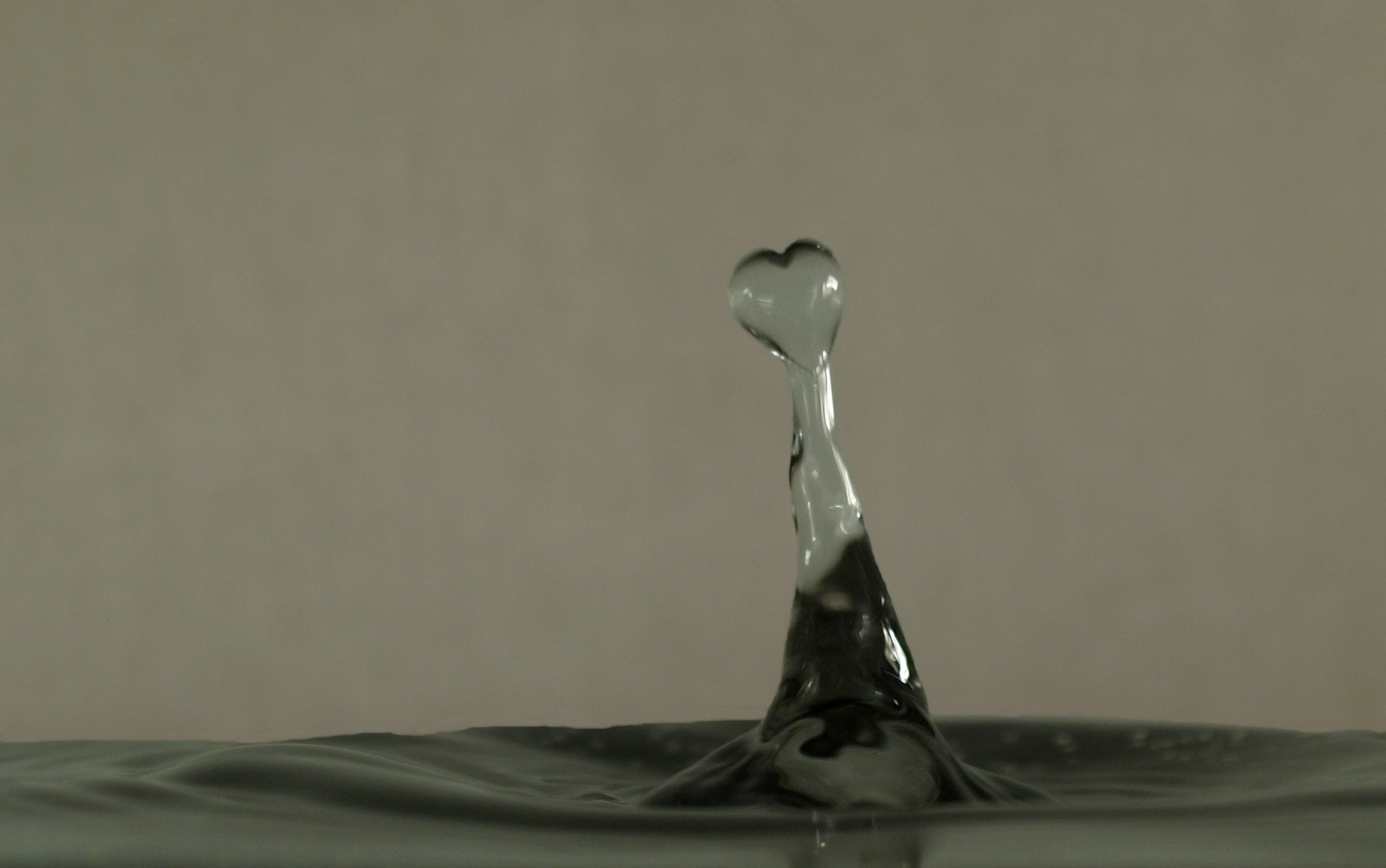 water splashing from a spoon into a dark liquid