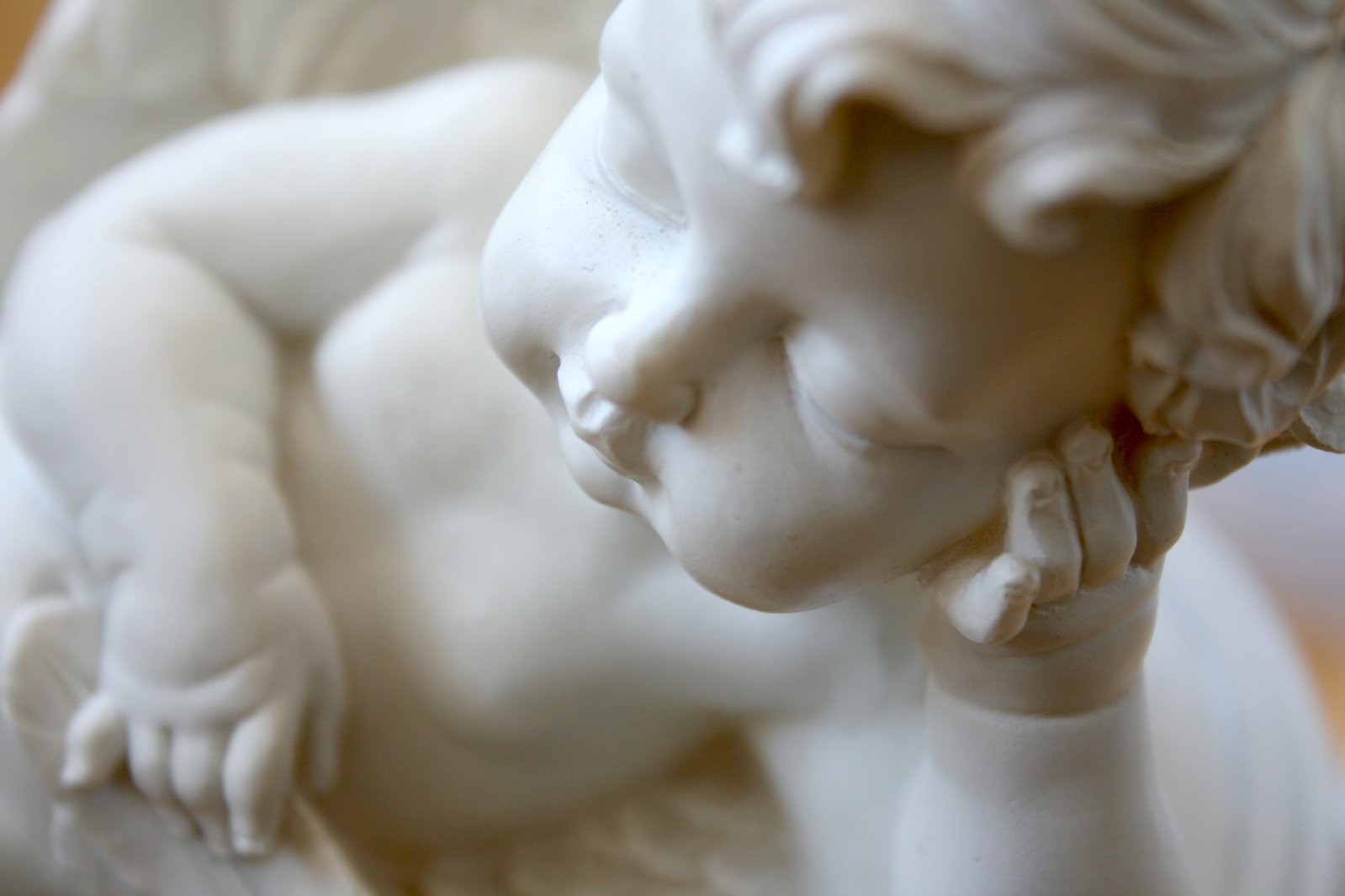 the child's face rests against the edge of a statue
