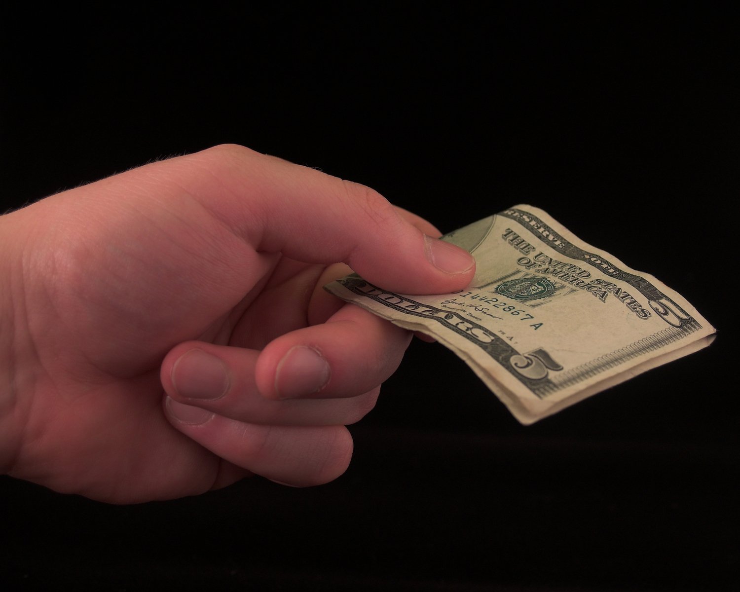 a hand is holding a twenty dollar bill