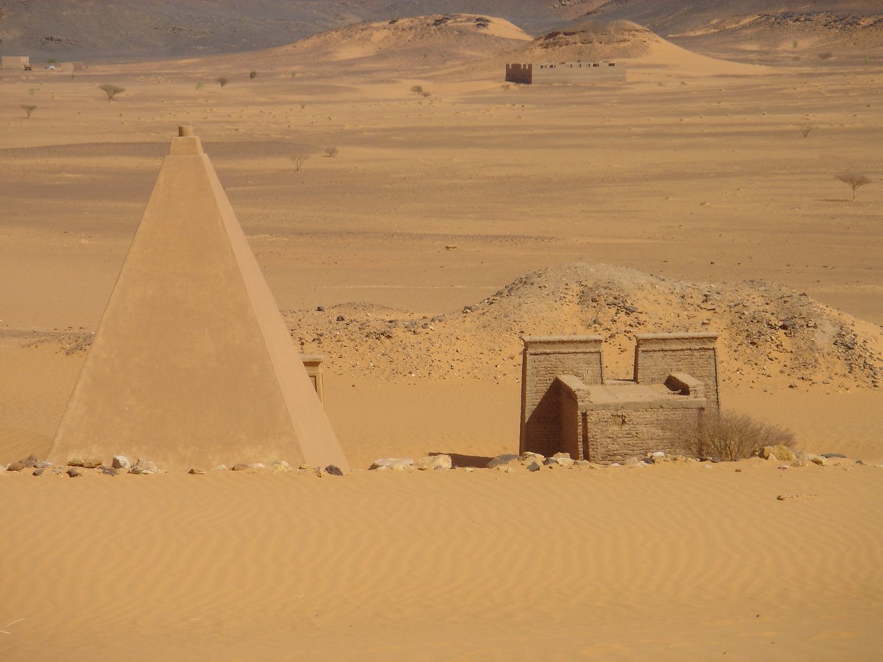 there are two sand structures standing in the middle of the desert