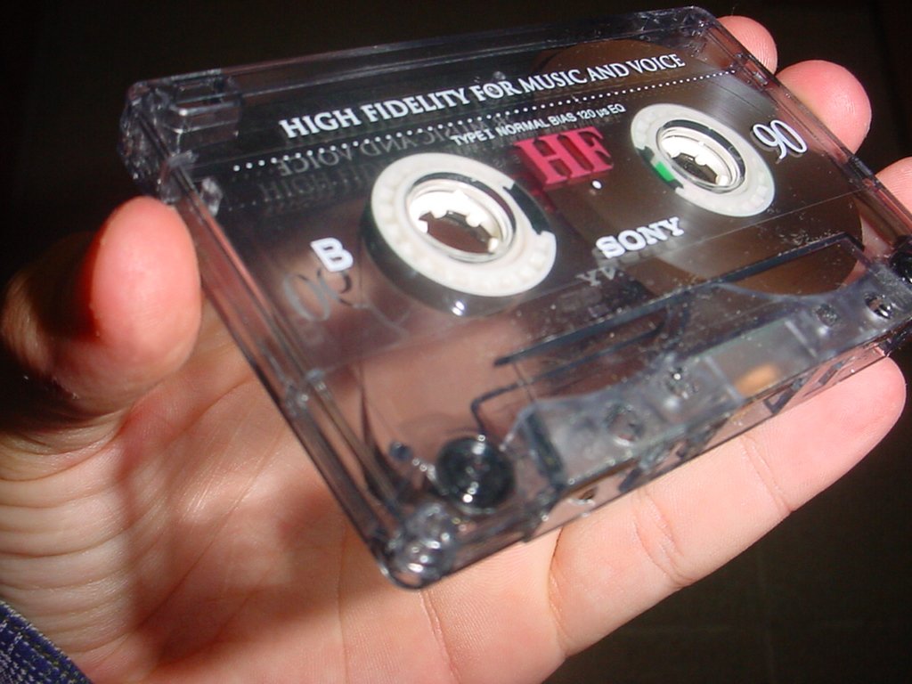 a person holding an audio cassette in their left hand