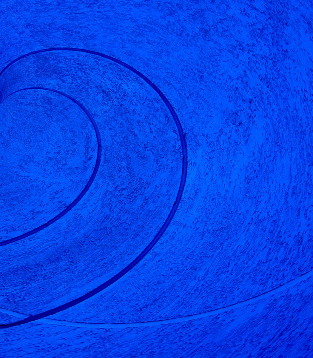 a circular painting in blue tones with the colors red, white, and blue