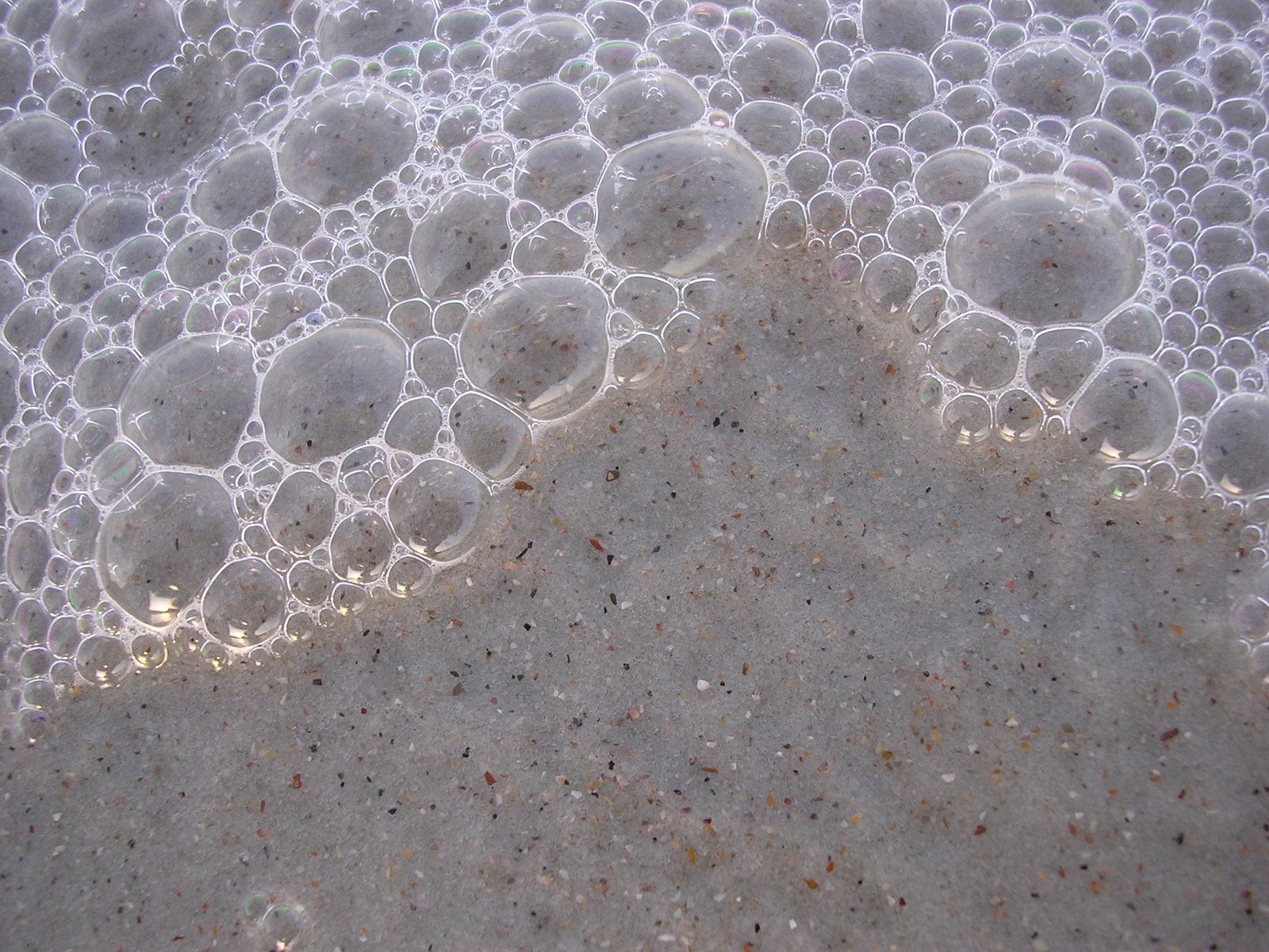 bubbles in the sand and a brown object is laying on it