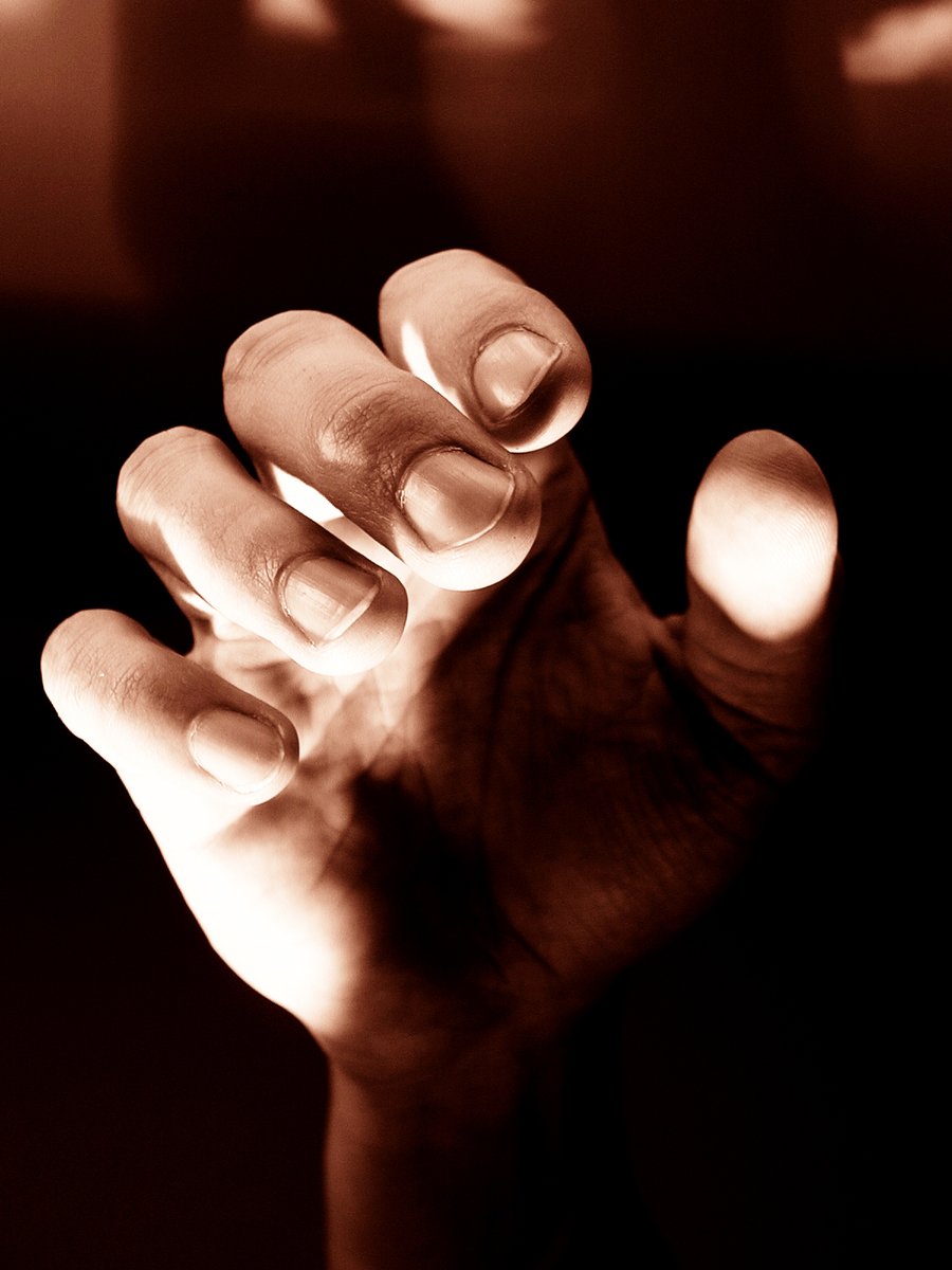 a person holds their hand up in the dark