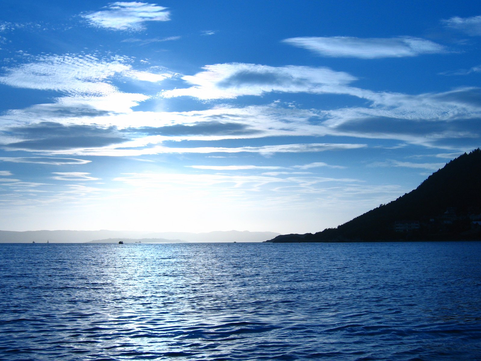 the water at the bottom of the cliff is blue and clear