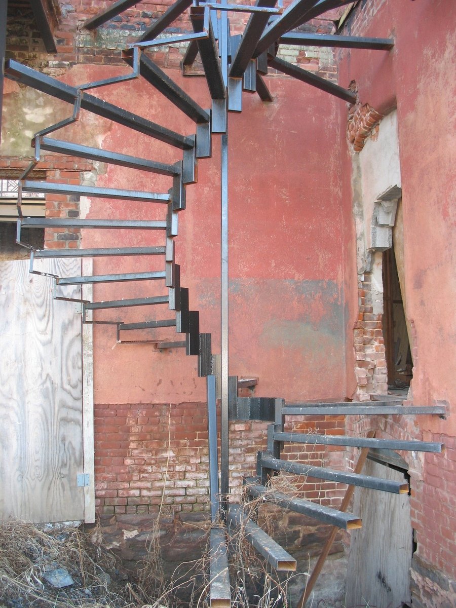 a set of metal stairs hanging over a concrete building