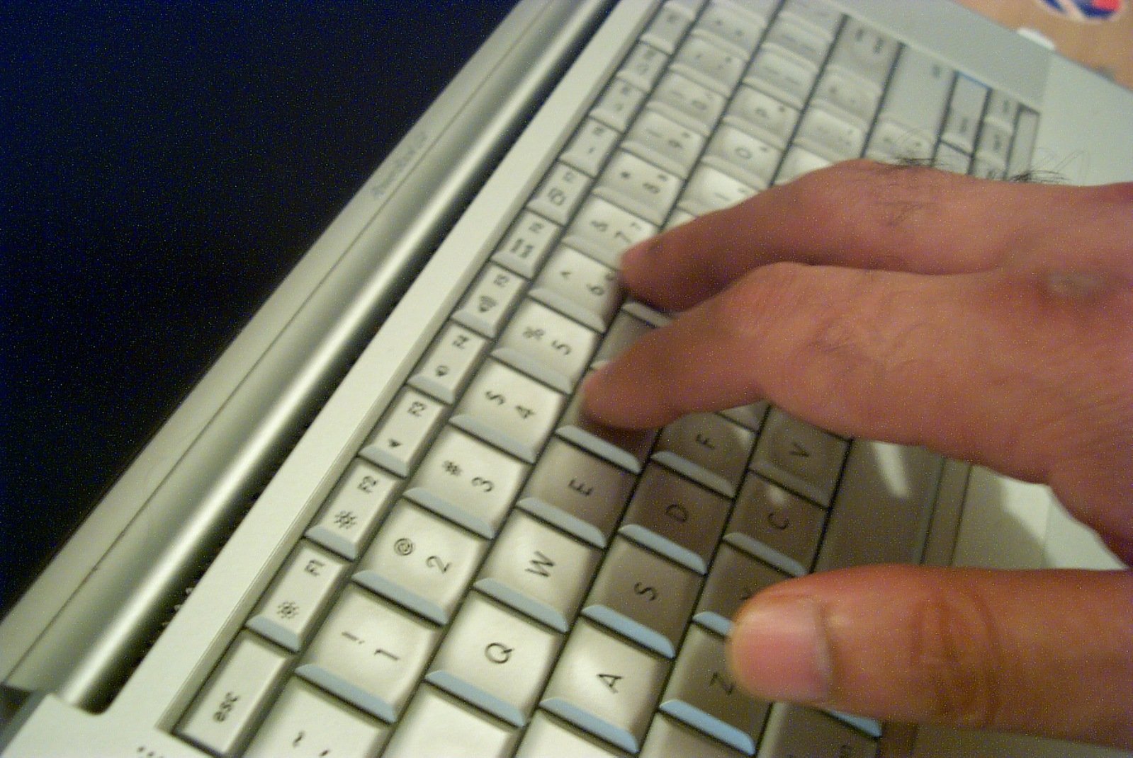 someone typing on a white computer keyboard