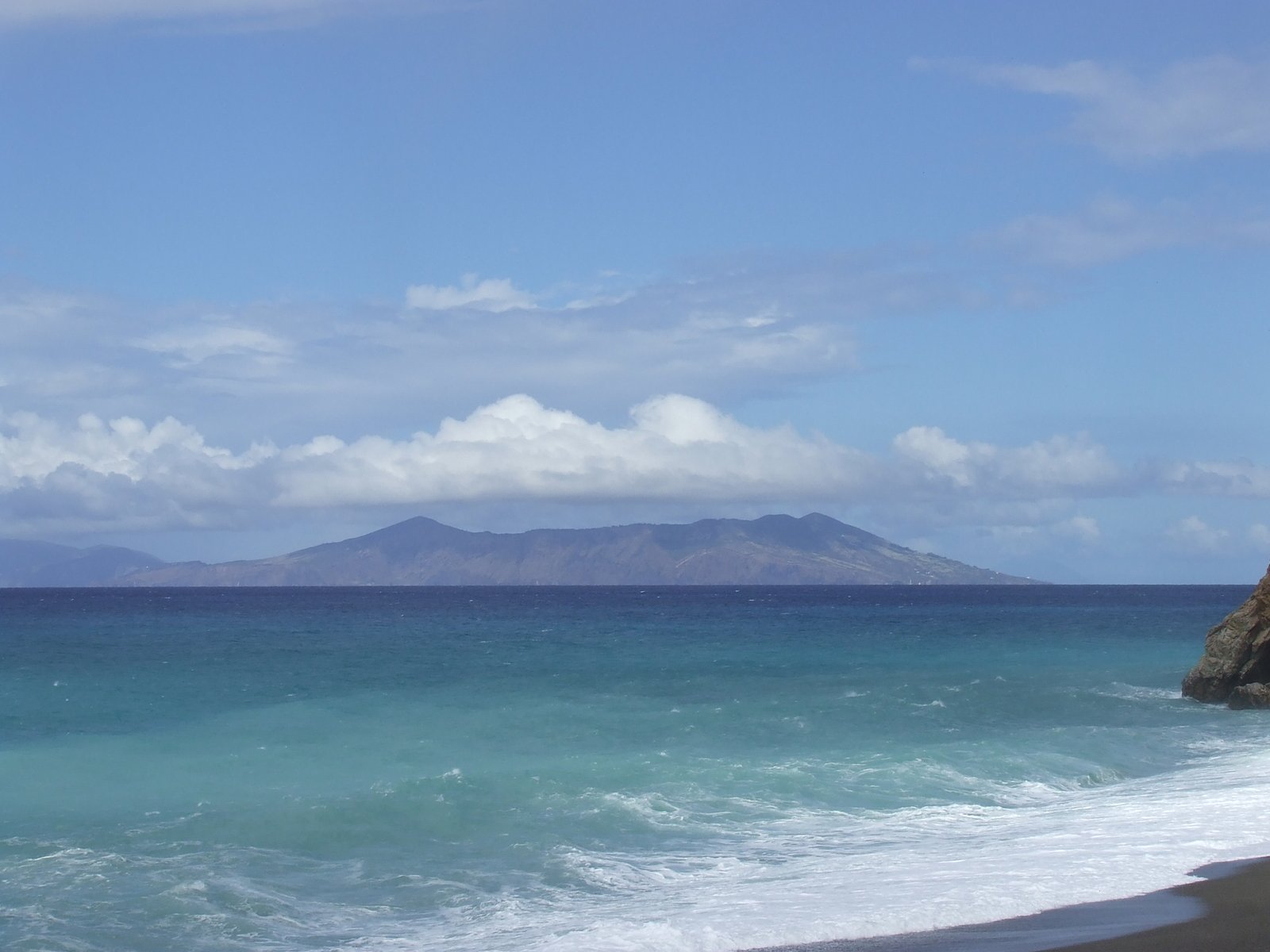 a sandy beach with a mountain in the background