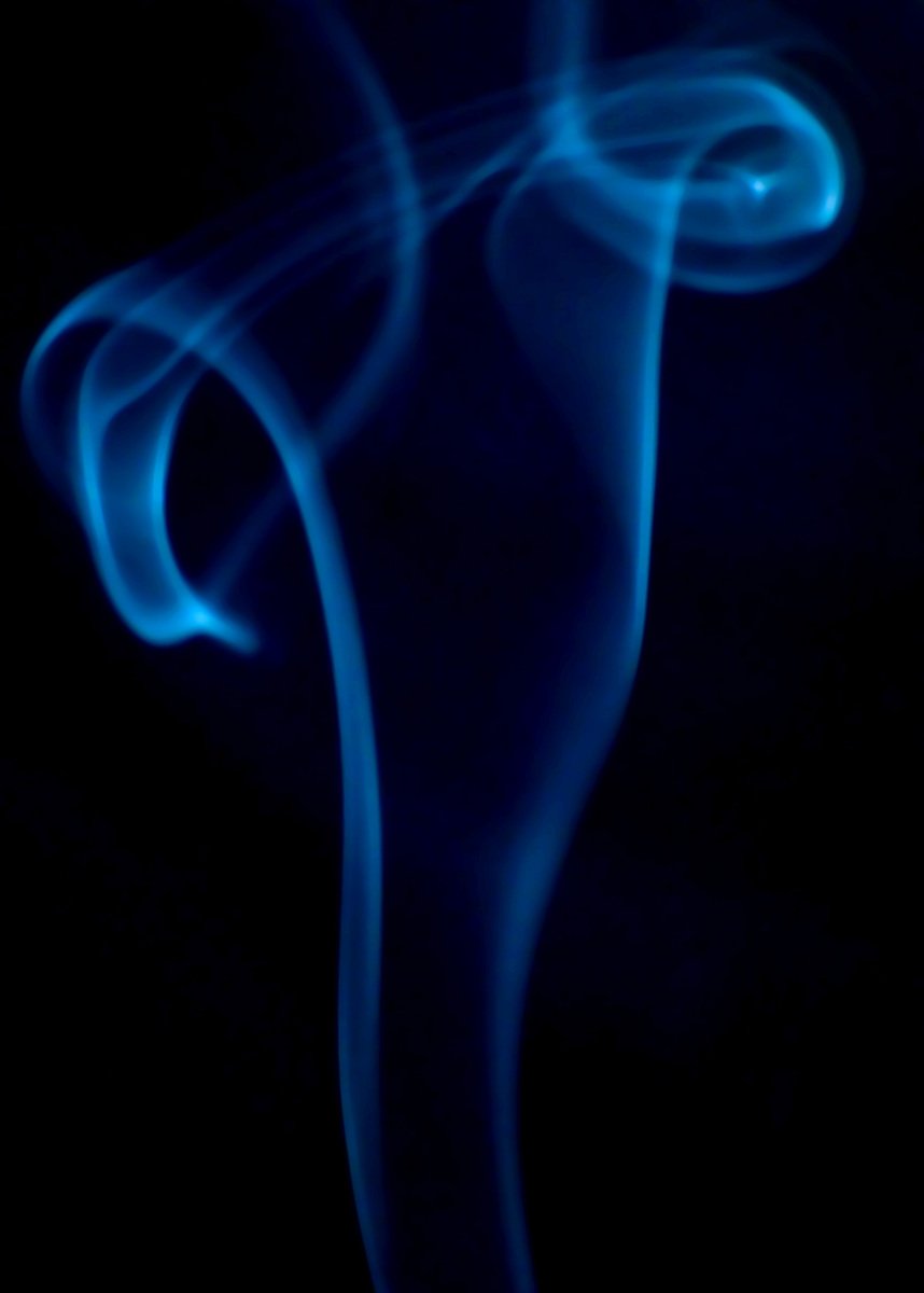 blue smoke rising up into the air in the dark