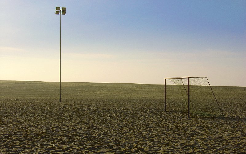 two soccer goal posts stand in a barren field