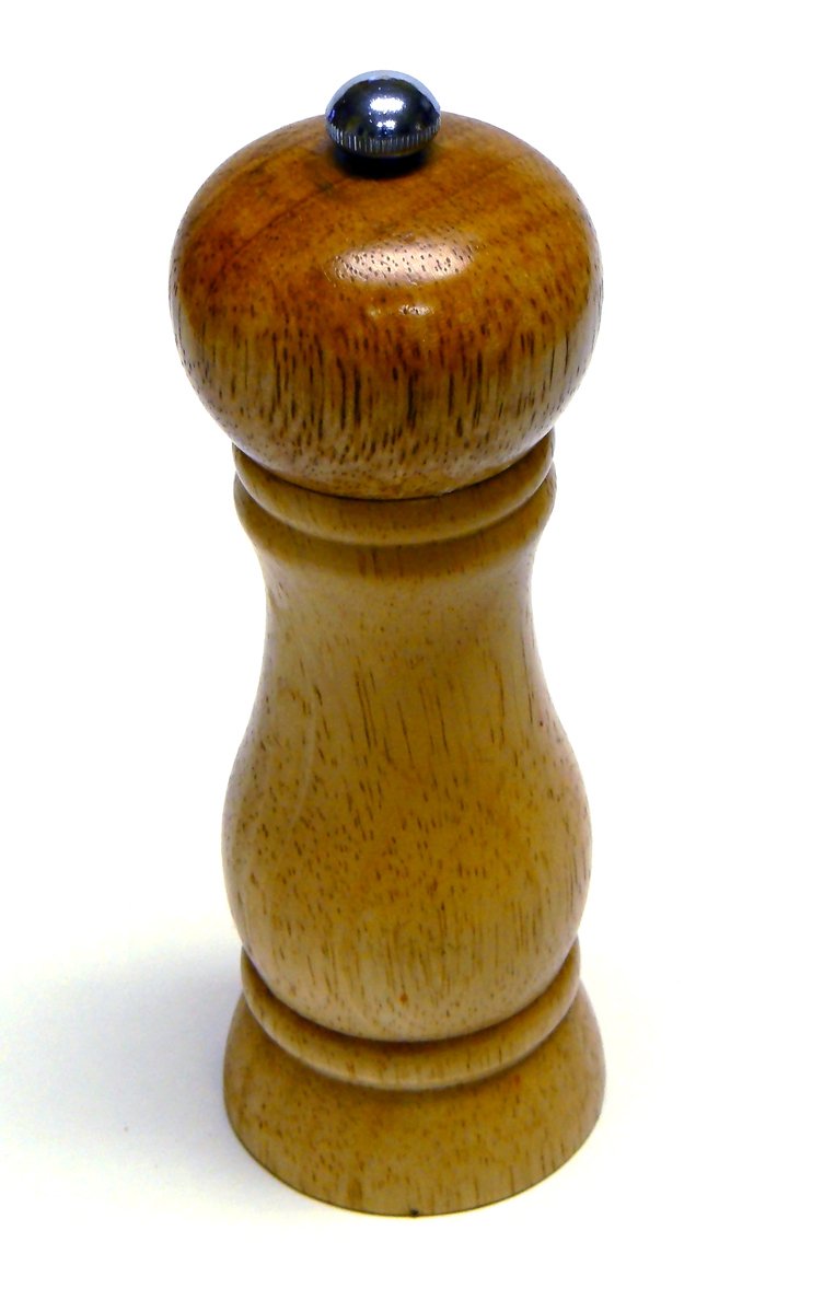 a pepper mill on a white surface with a black top