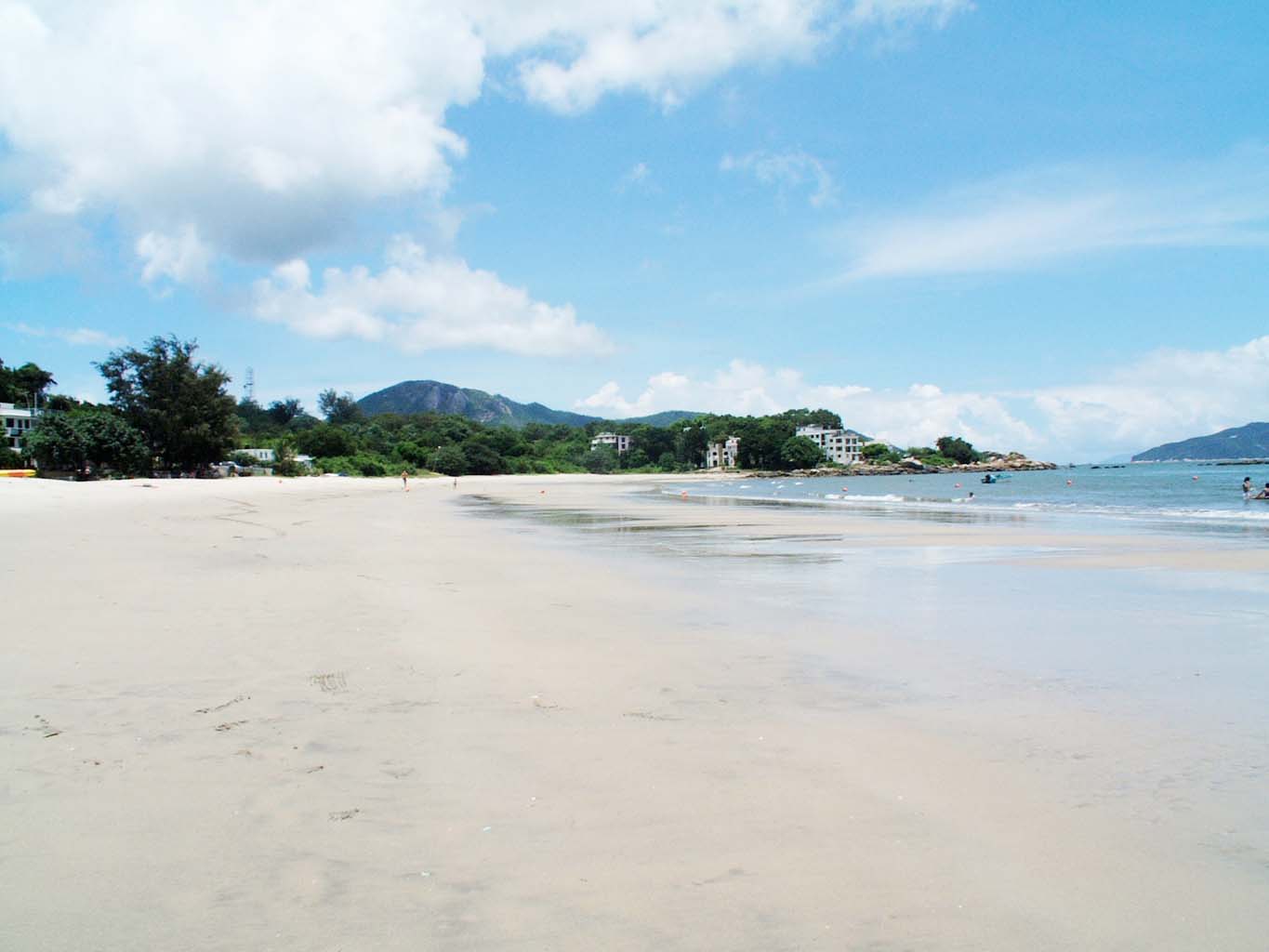 a white sandy beach surrounded by mountains and water