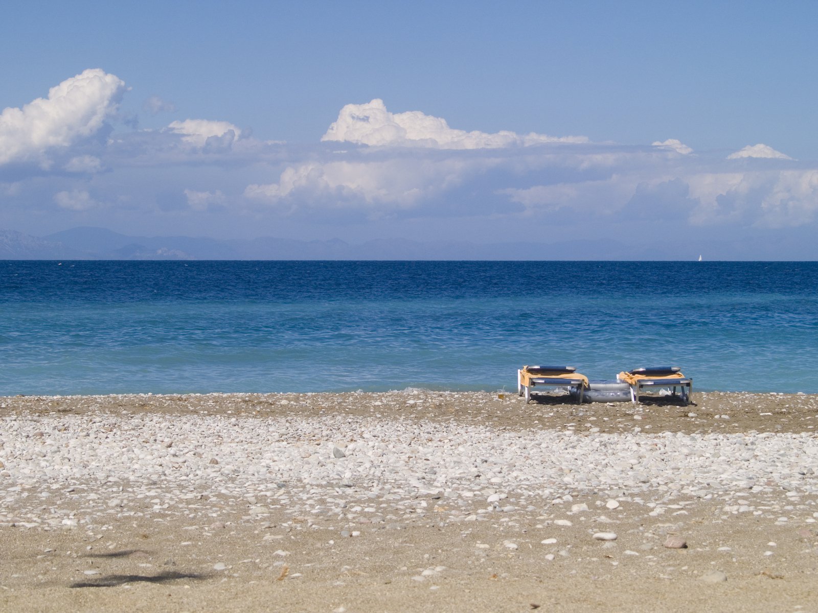 two boats are out on the beach, beside a couple