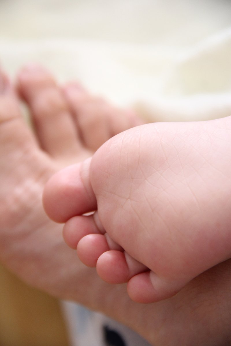 a baby's feet and toes are sitting in the lap