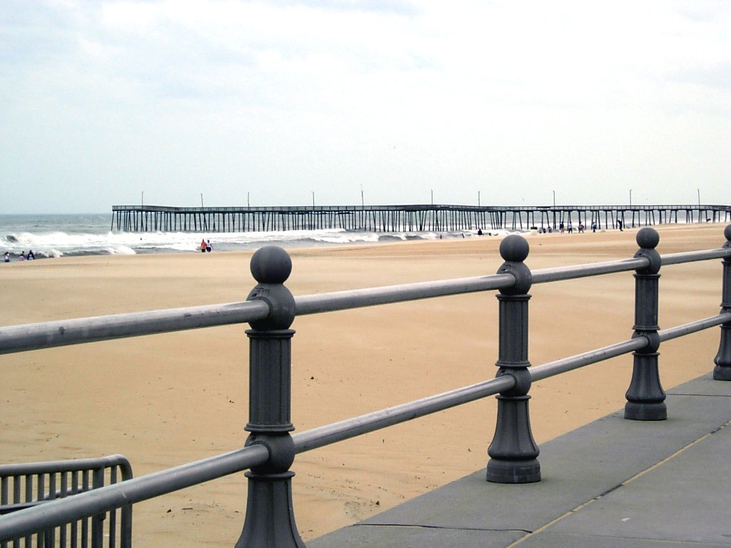 a railing with two poles that are in front of the water