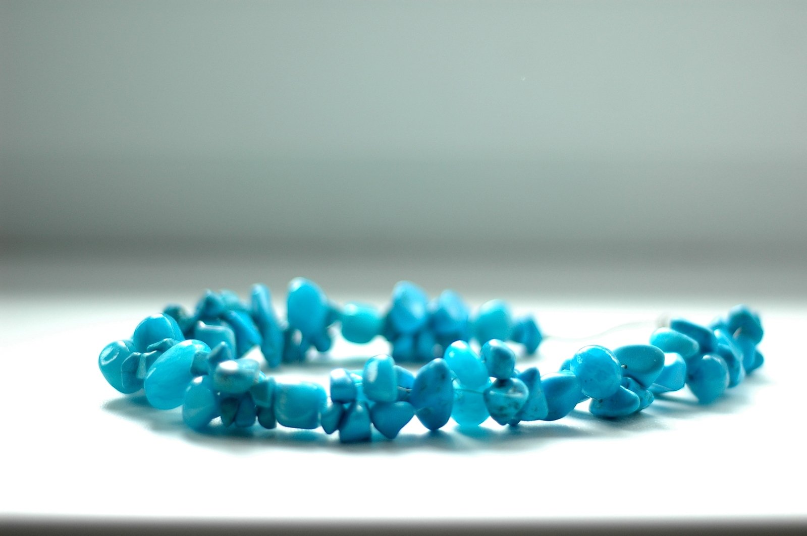 turquoise beads that are laying on a table