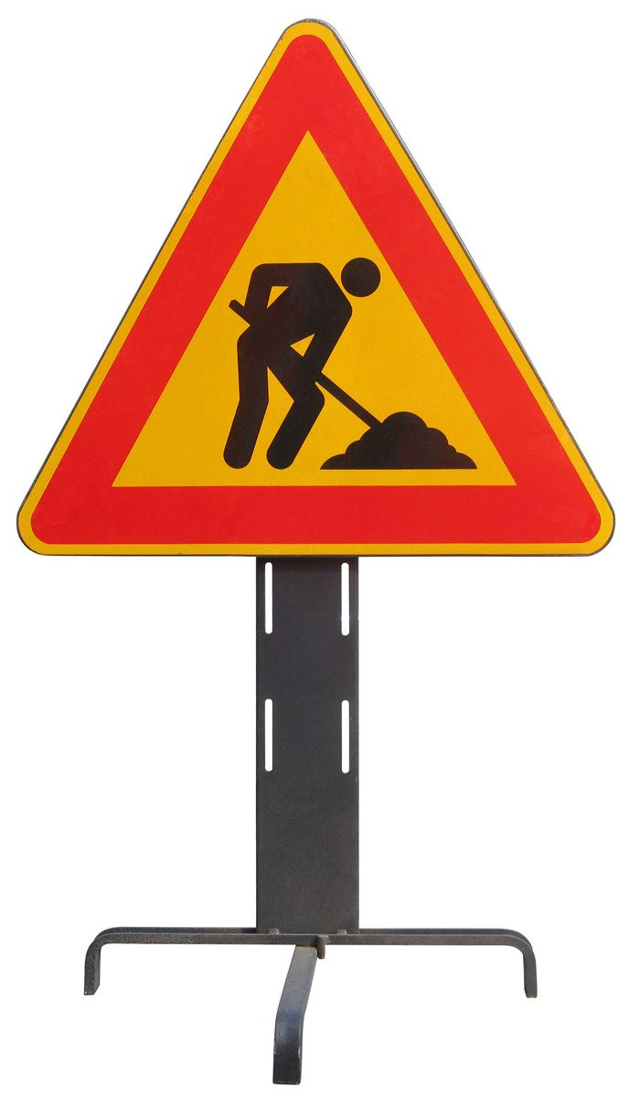 a red and yellow triangular sign with a man digging under it