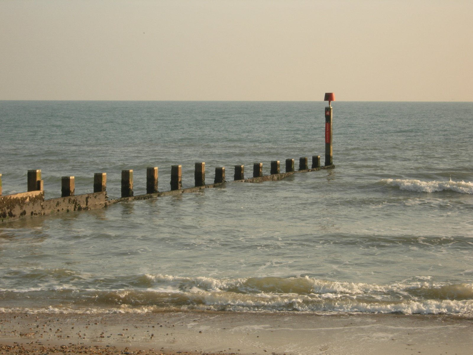 an empty pier is shown next to the beach