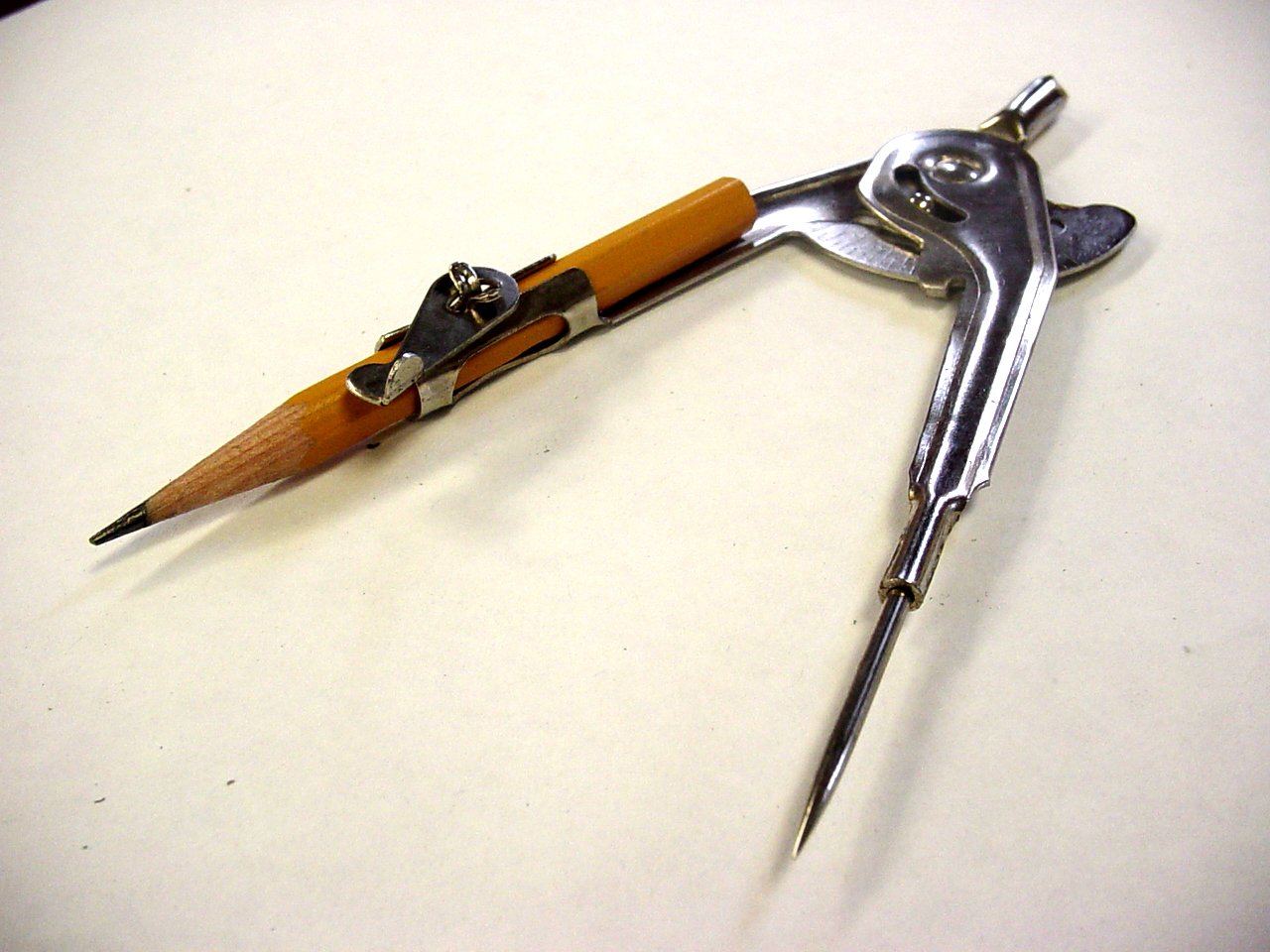 an antique manining tool with a wooden handle on a white surface