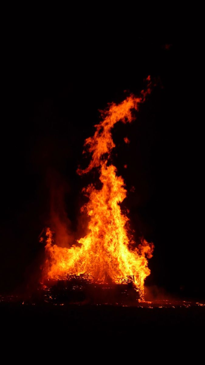 a pile of orange and red lava rocks in the night sky