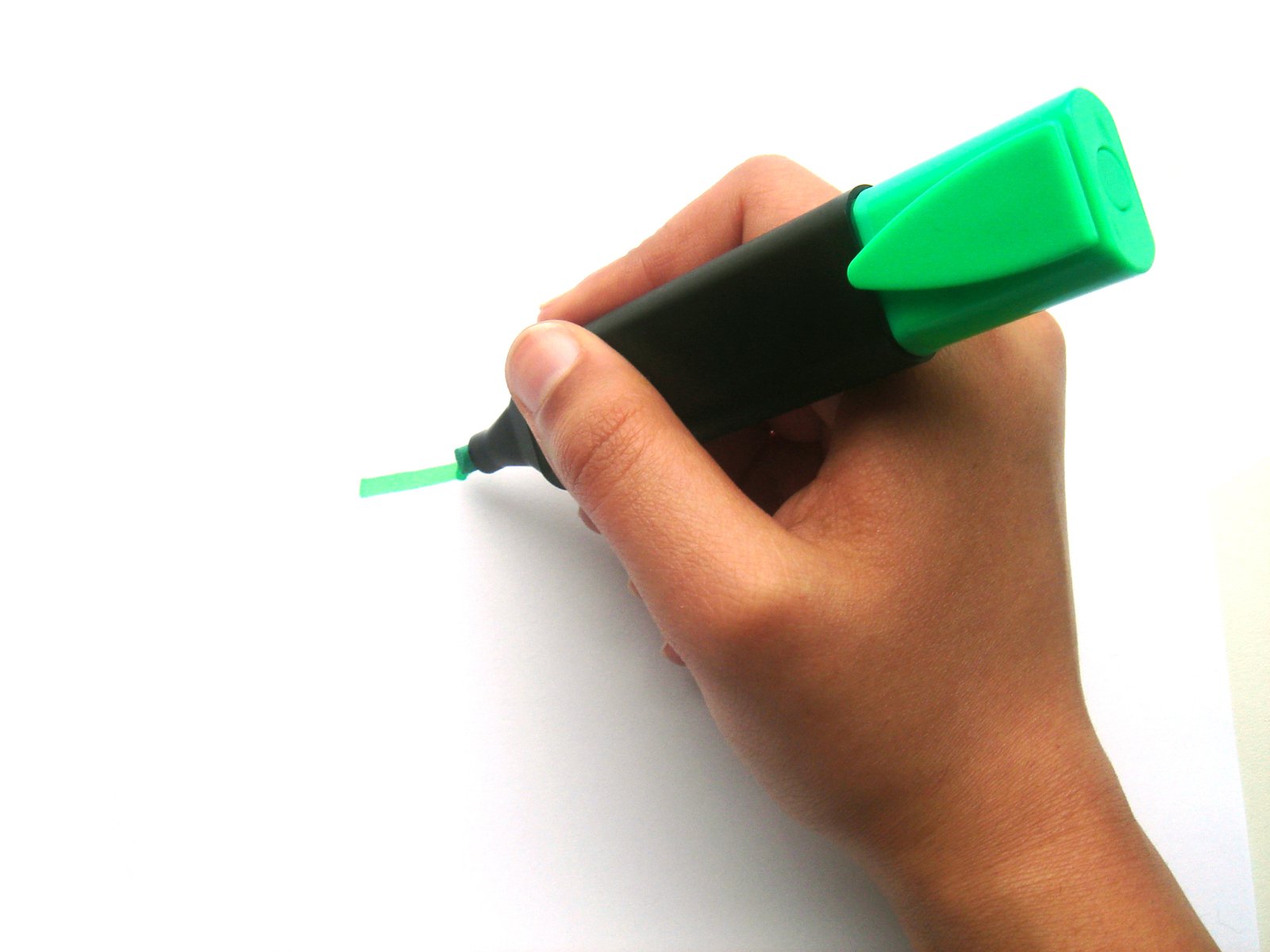 a person writing on paper with a pen