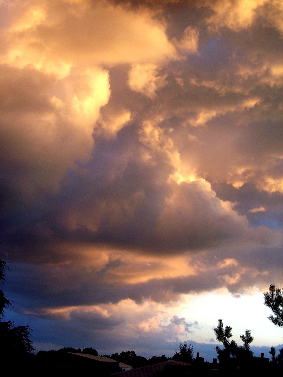 the clouds are forming an orange glow against blue sky