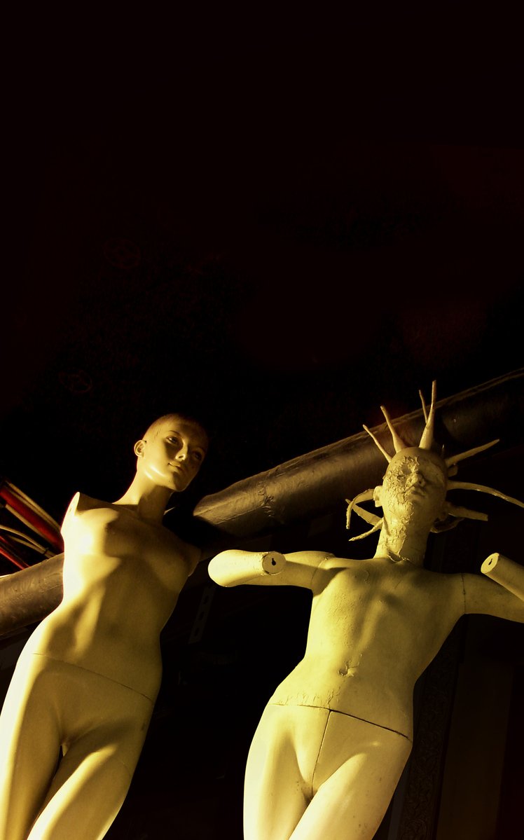 two statues standing next to each other with arms extended