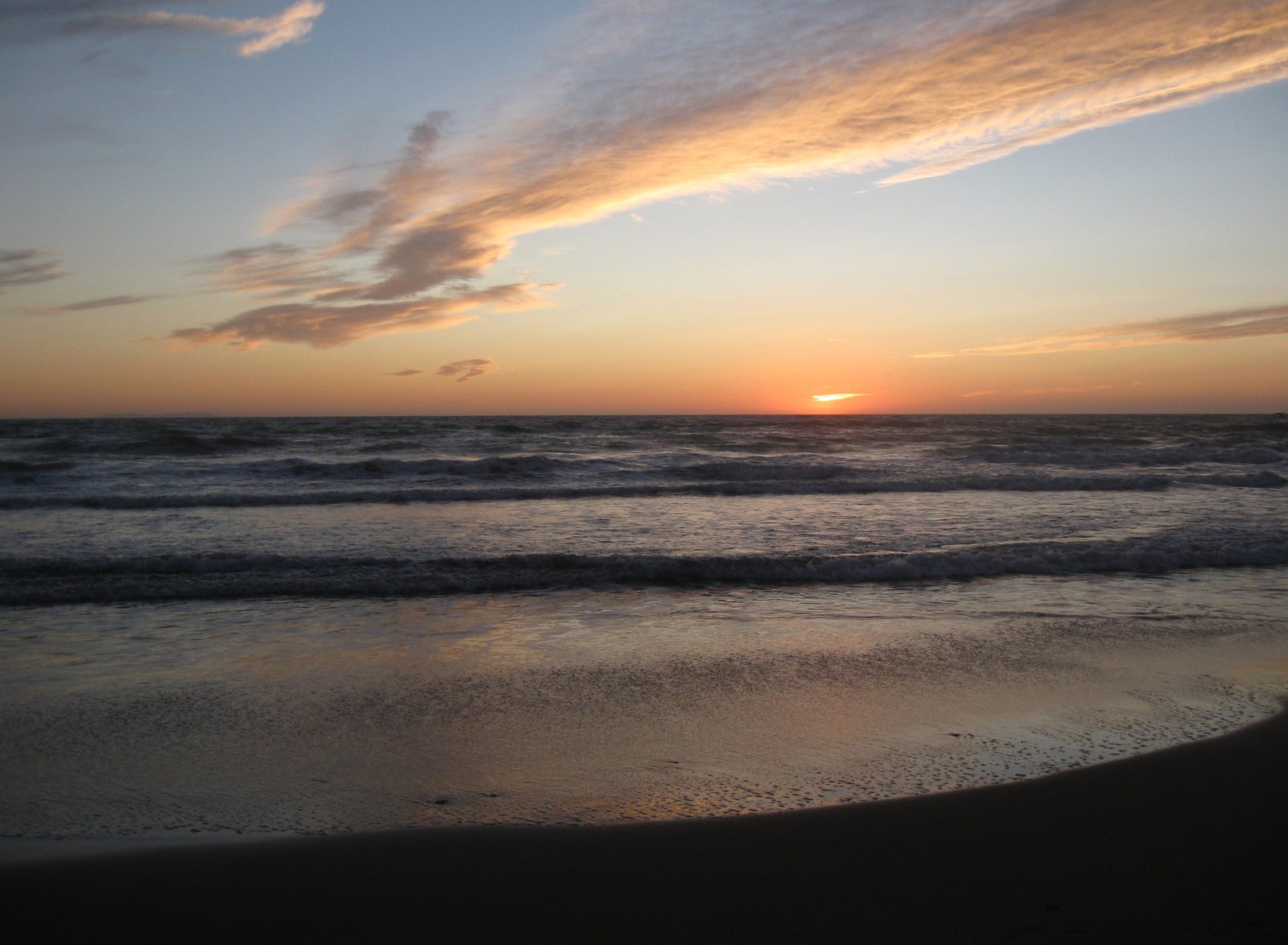 the sun is setting over a large body of water