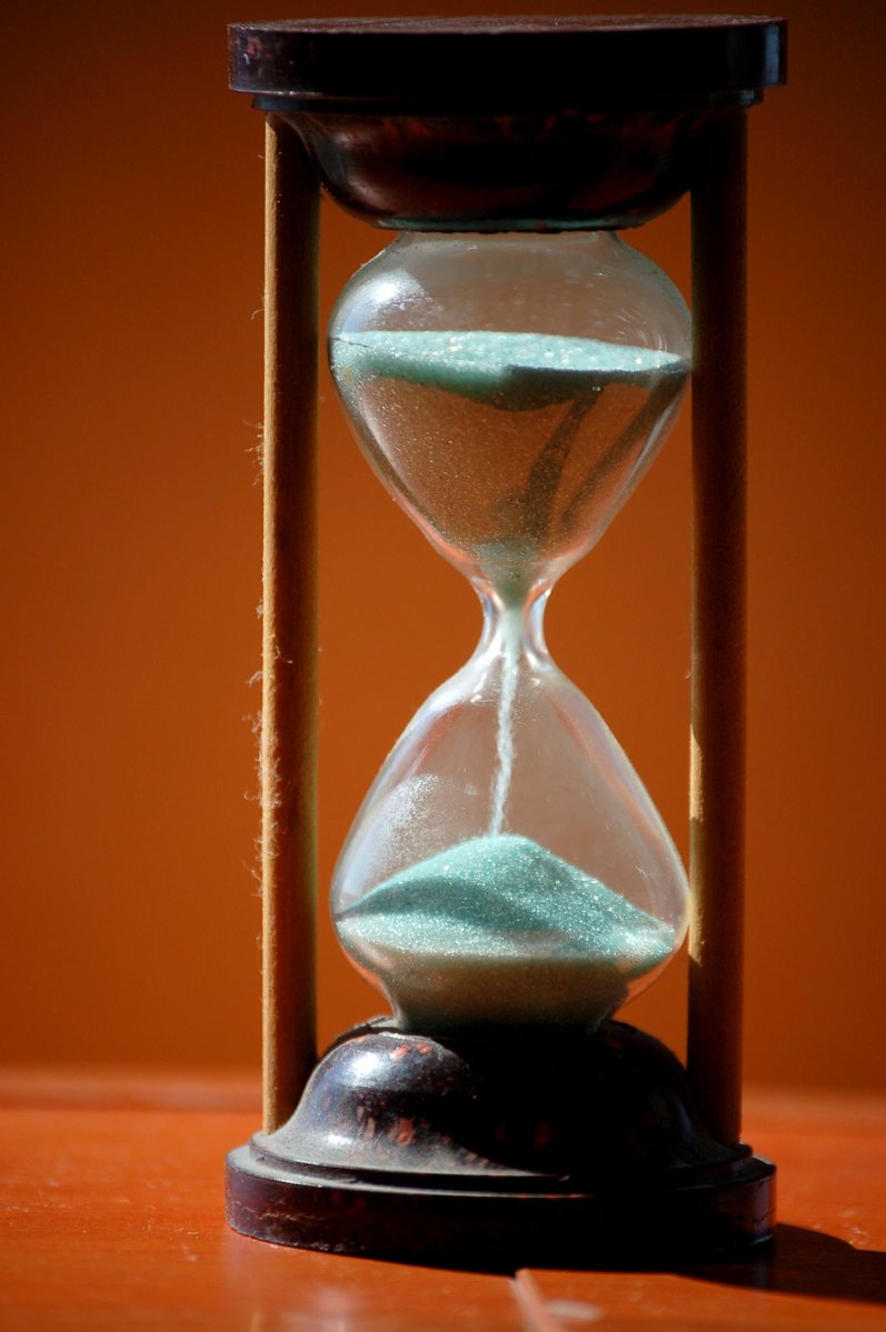 a sandglass on the ground with sand flowing through the top of it