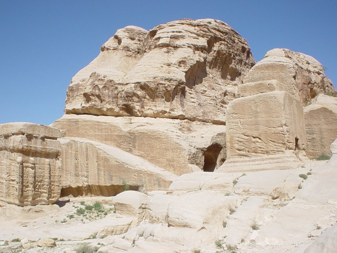 a large stone structure surrounded by desert like terrain