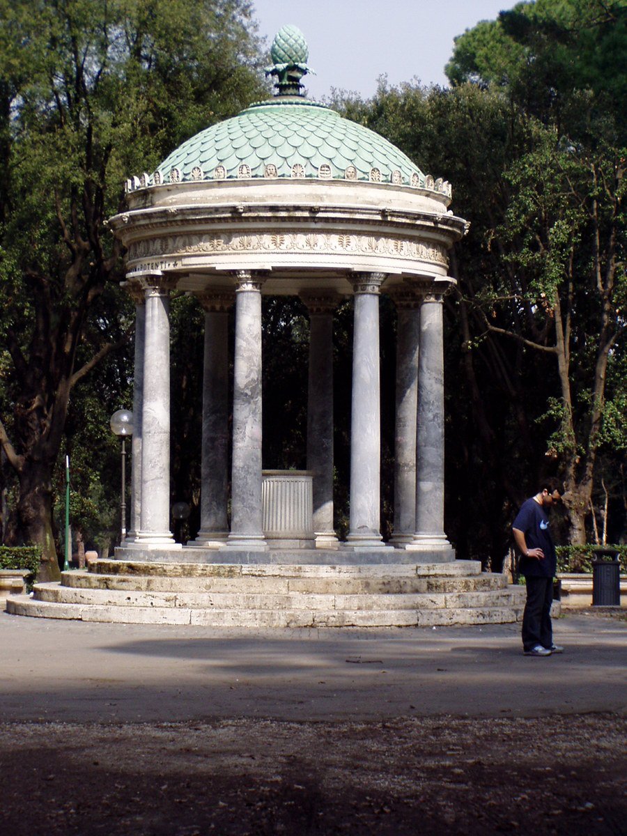 a man is standing in front of an old looking circular structure
