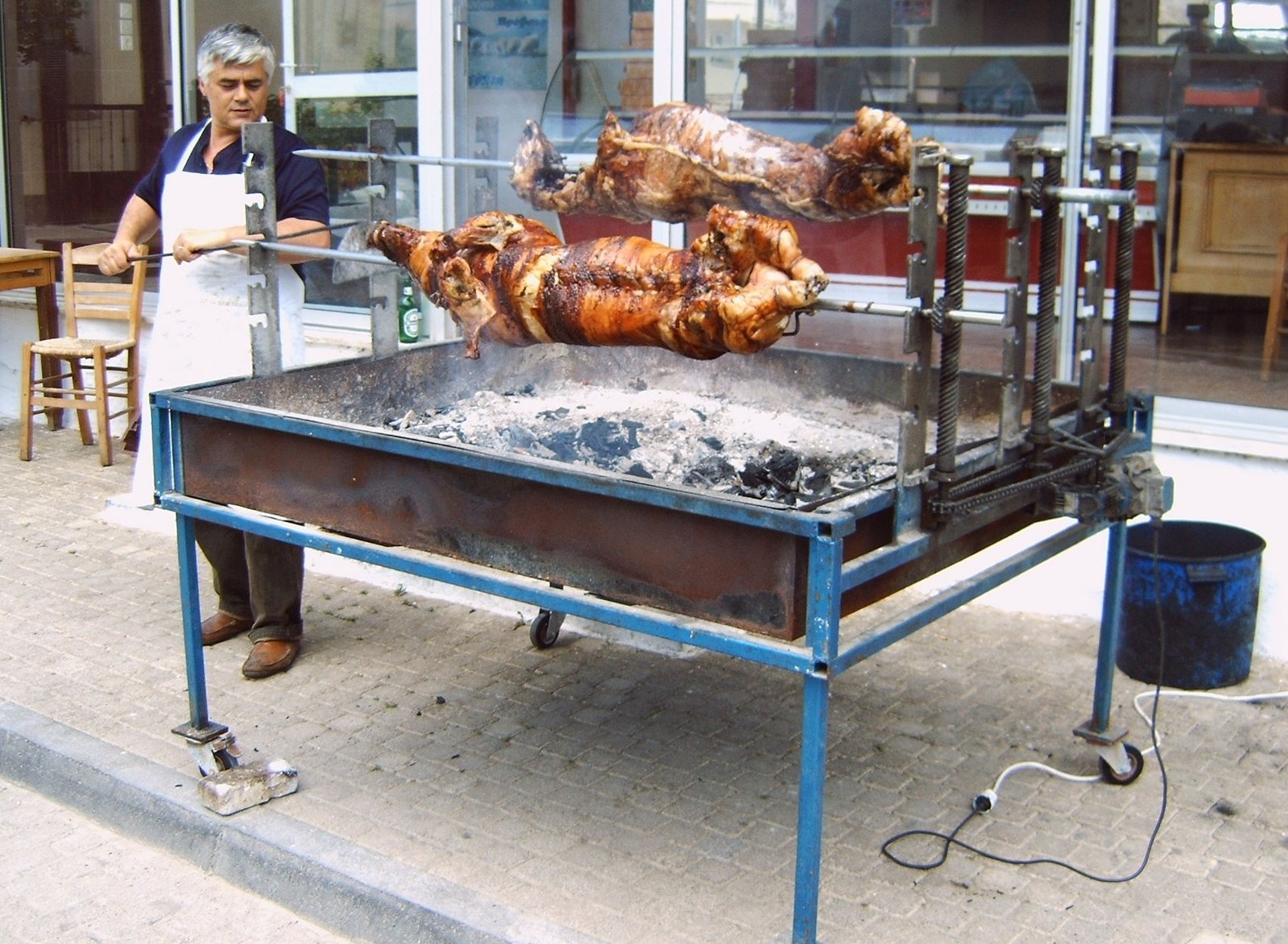 a man standing behind a table with three pieces of chicken on it