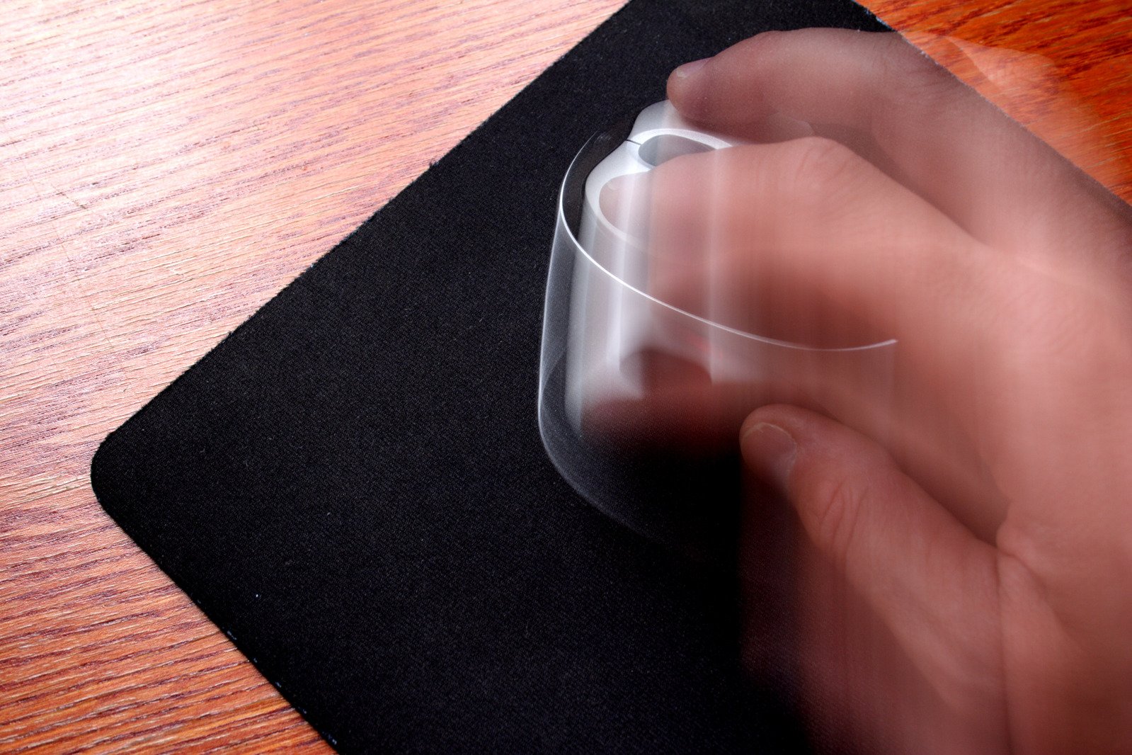 a person is holding a mouse on top of a mousepad