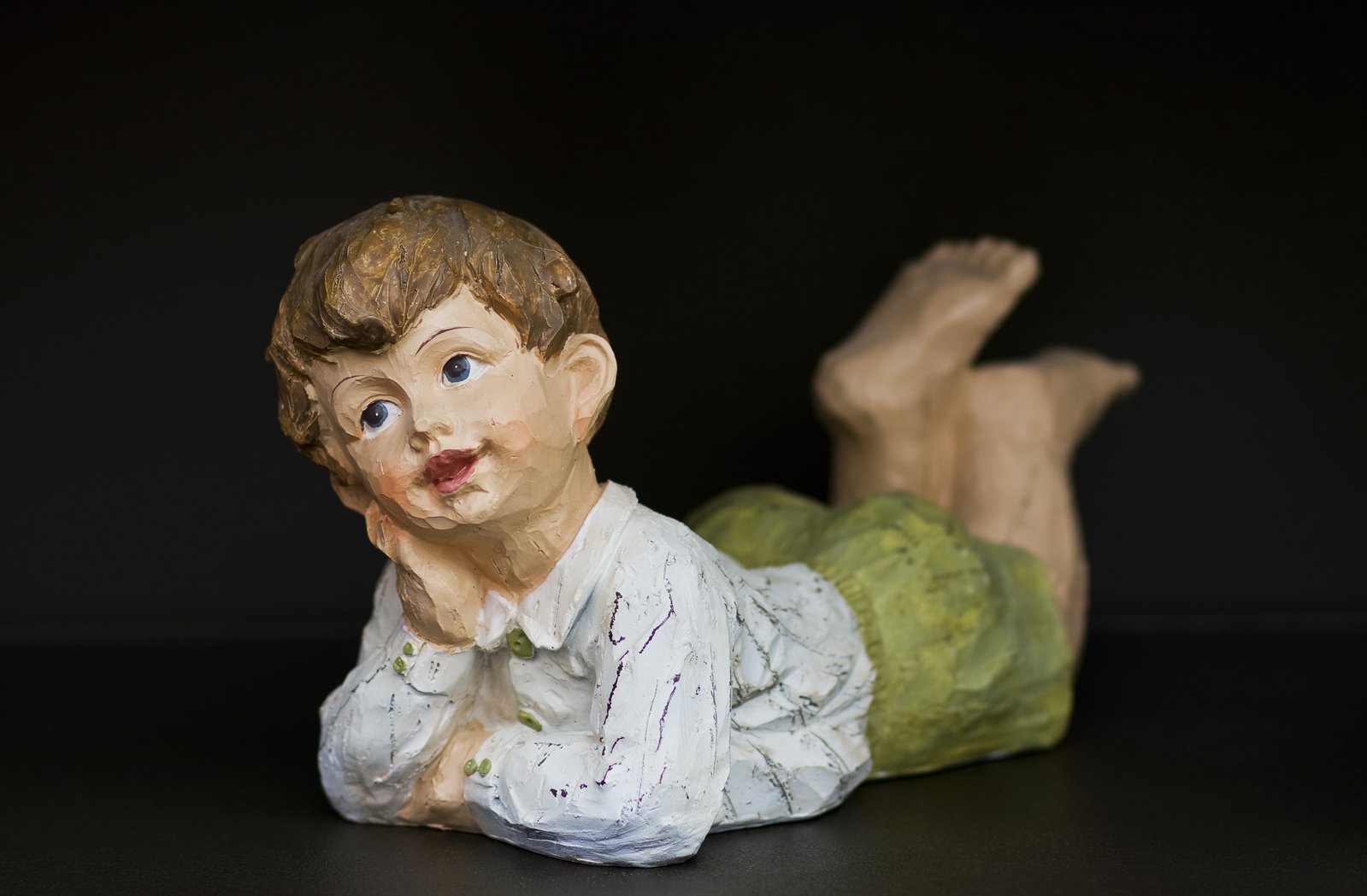 a plastic child figurine laying on it's stomach