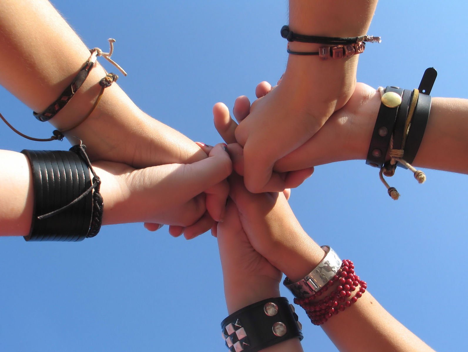 four people standing in a circle together holding hands