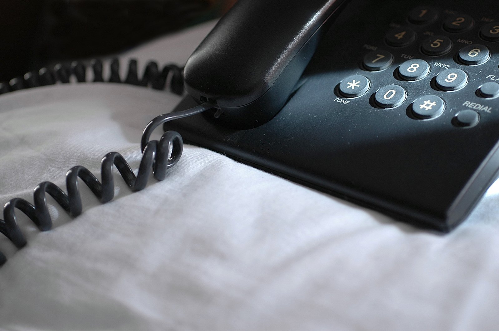 a phone sits on top of the white sheet