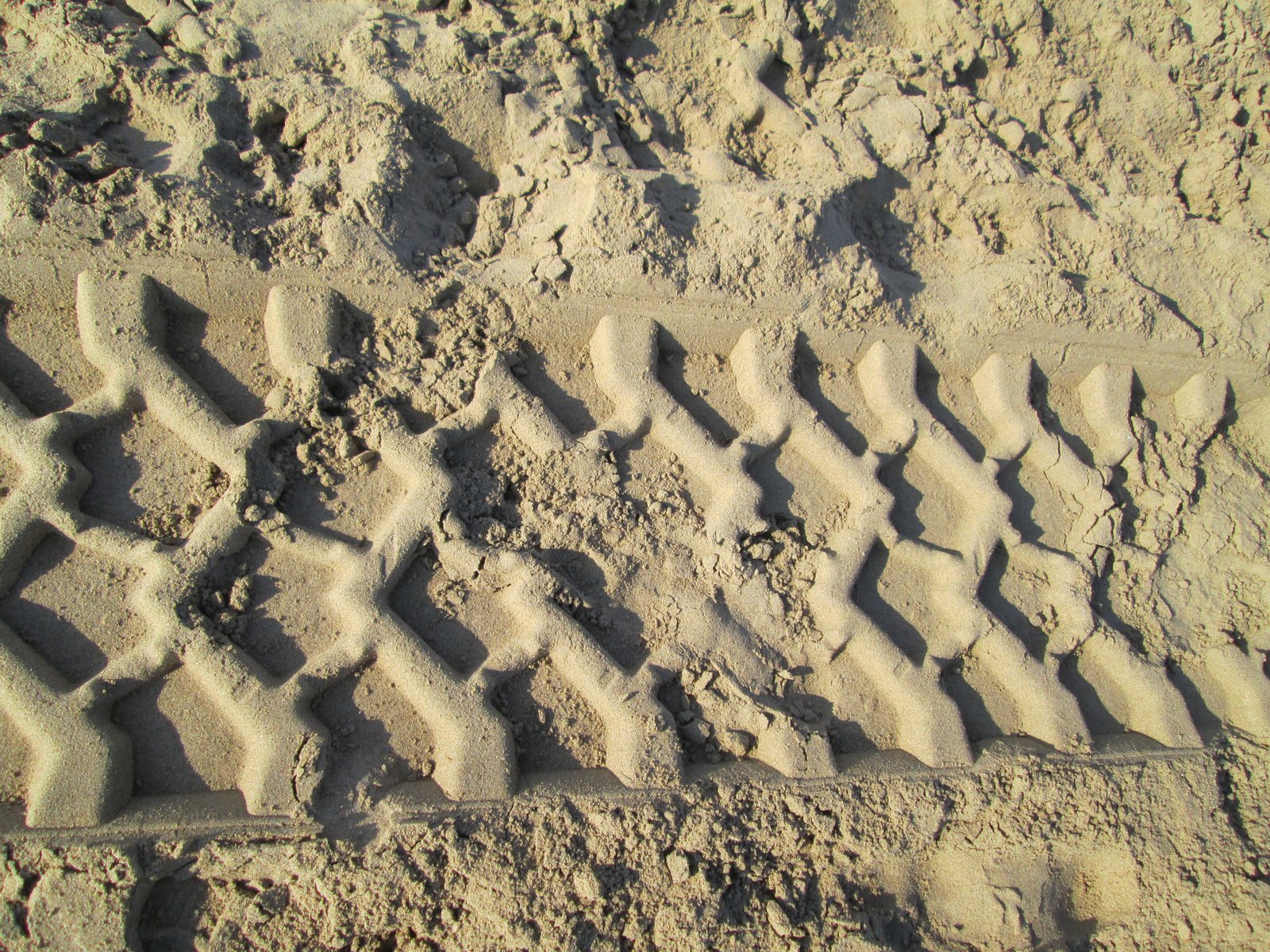 a dirt tire imprint on a sandy beach