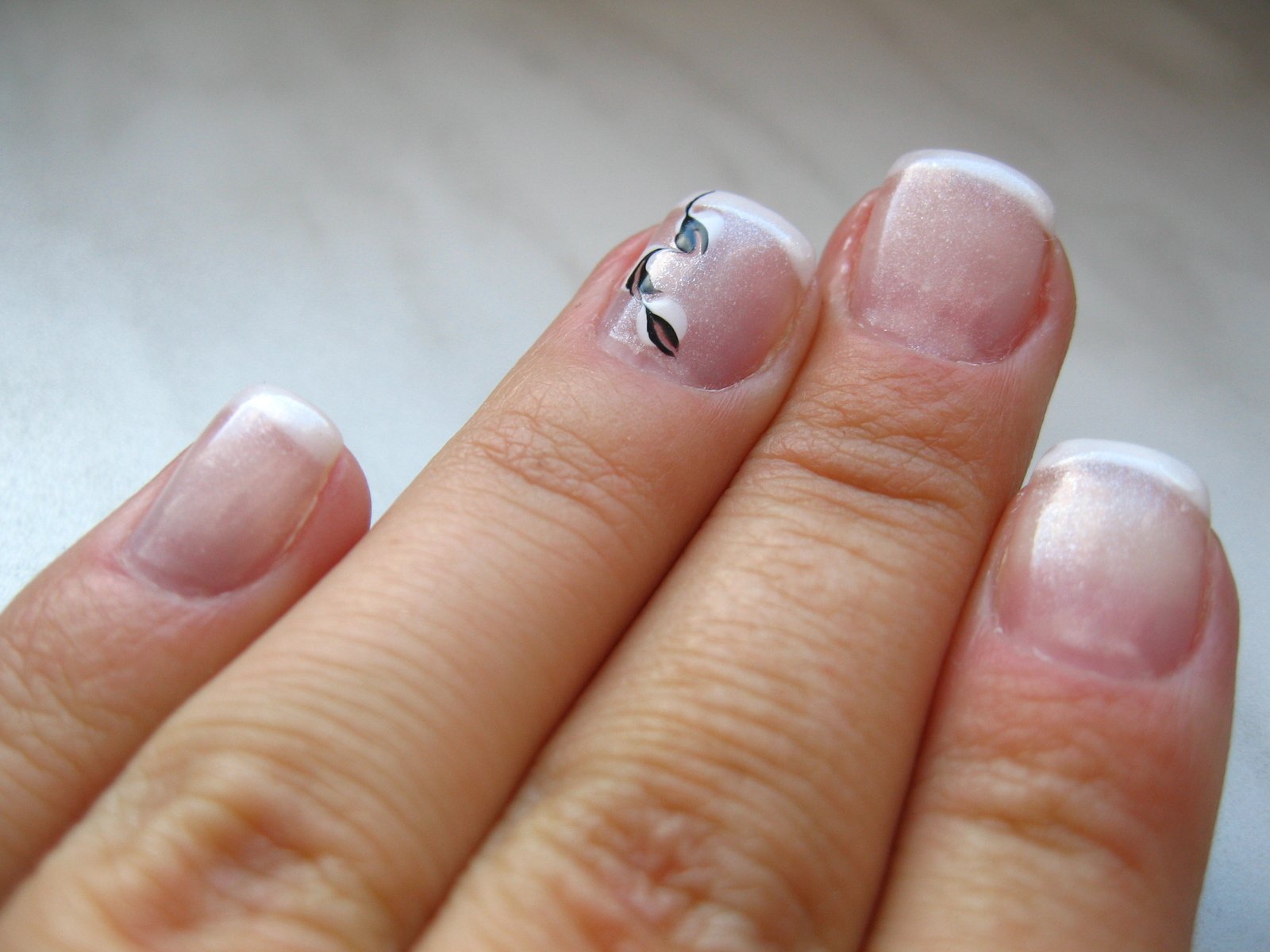a person with a white and black nail polish on their fingers