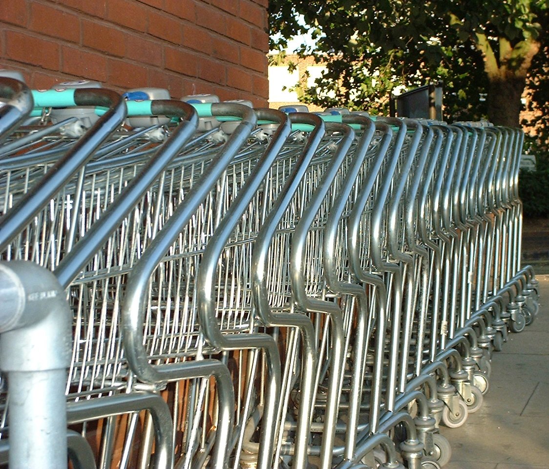 several silver metal carts parked on sidewalk next to building