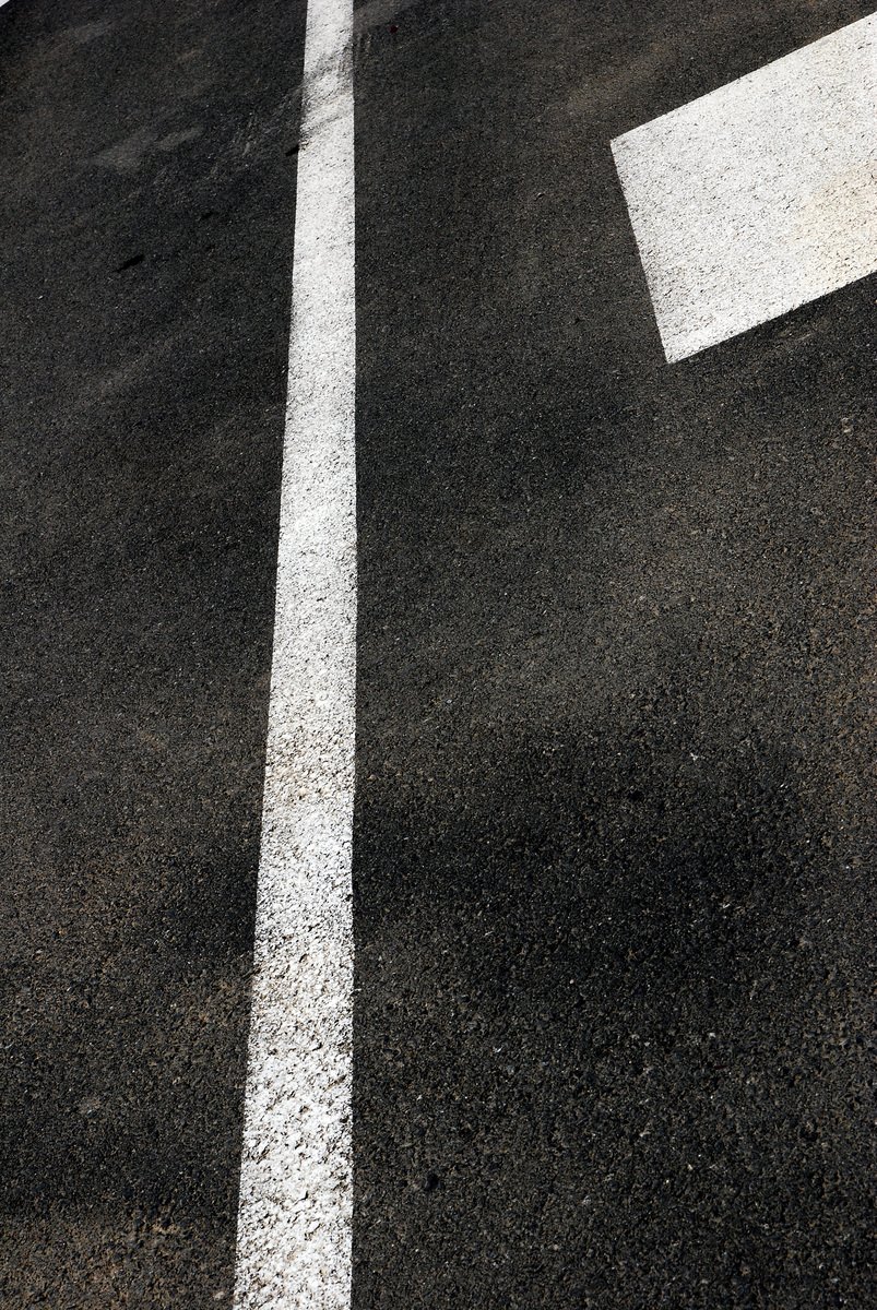 an empty parking spot with two white arrows painted on it