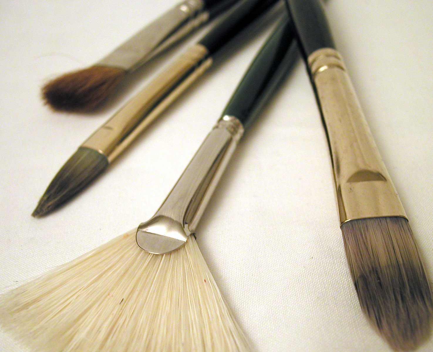 there are five different brushes on the white surface