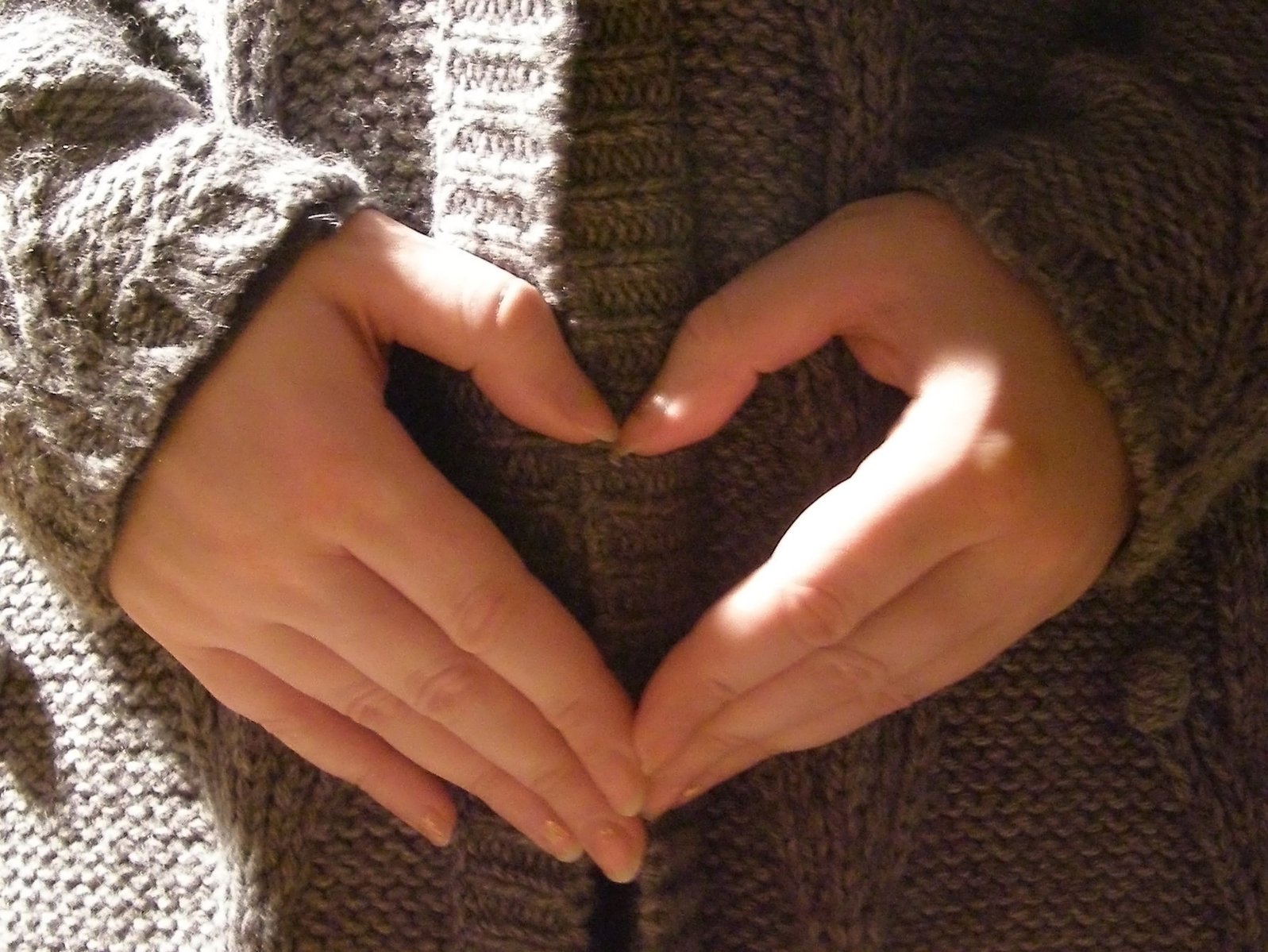 hands arranged heart shaped to form a sign