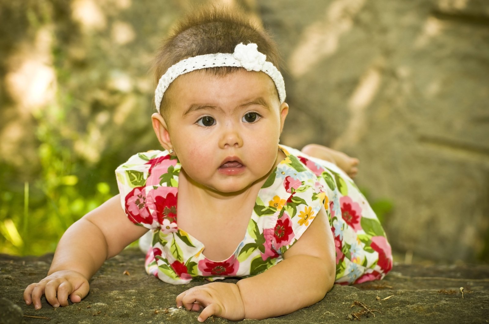 a baby girl laying down on the ground