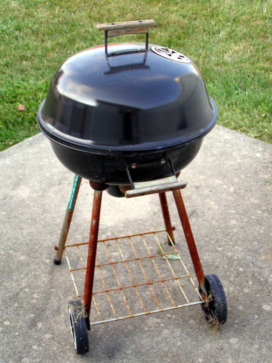 a large bbq grill is parked outside on the sidewalk