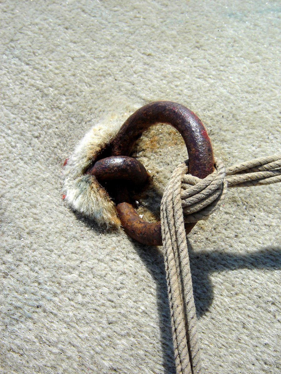 an old rusty ring is tied up to a rope