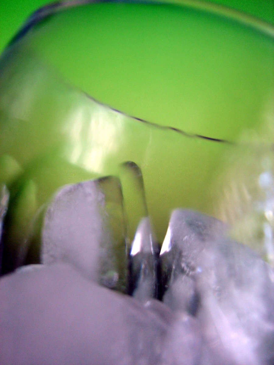 a blurry picture of a green vase with a silver substance