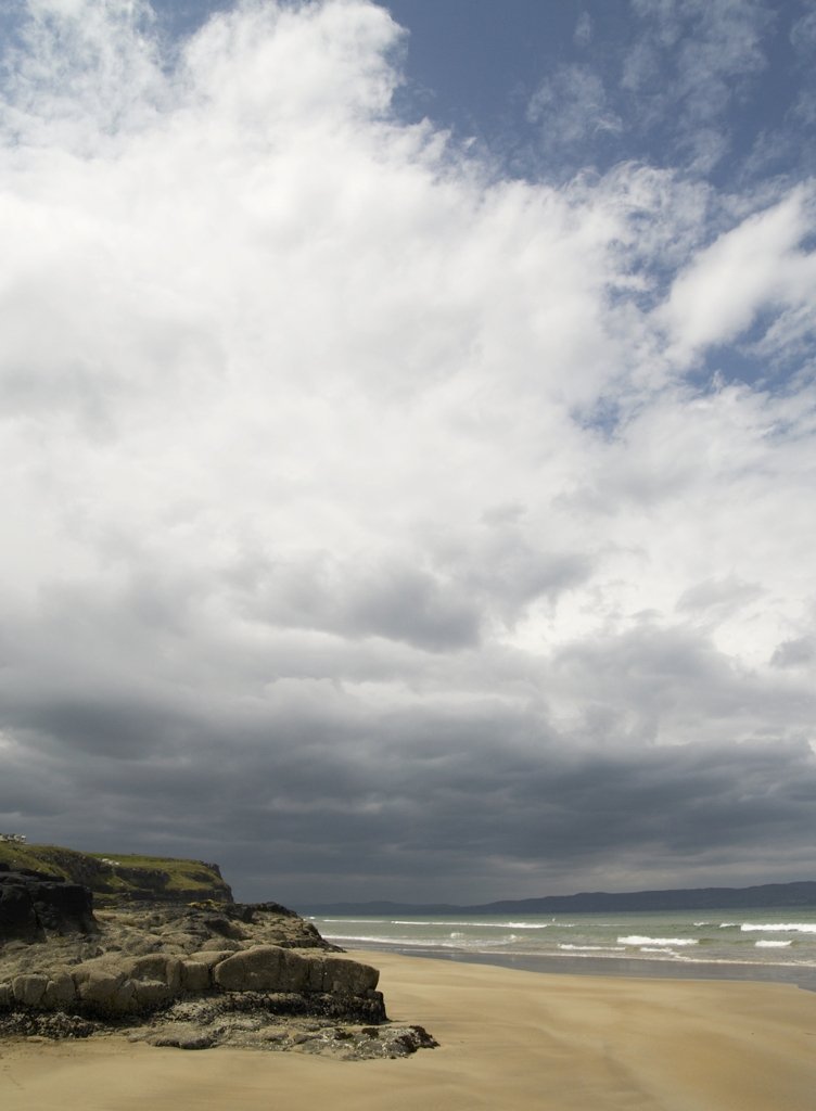 a person walking on a beach near the water